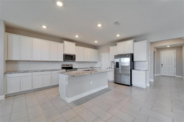 kitchen with appliances with stainless steel finishes, sink, an island with sink, and white cabinets