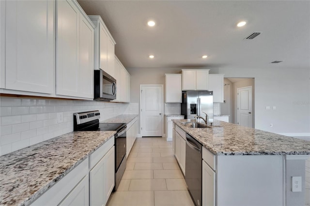 kitchen with a kitchen island with sink, sink, white cabinets, and appliances with stainless steel finishes