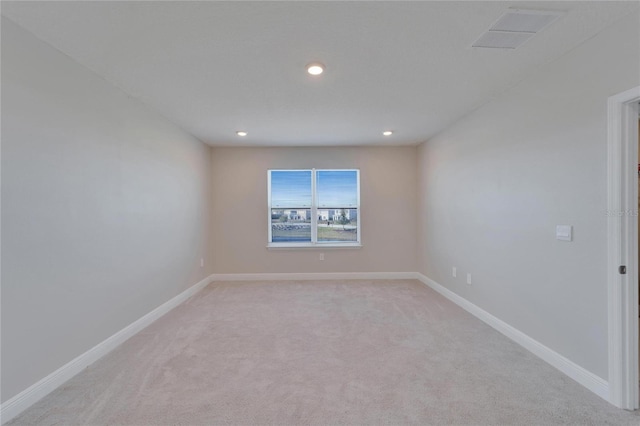 unfurnished room featuring light carpet