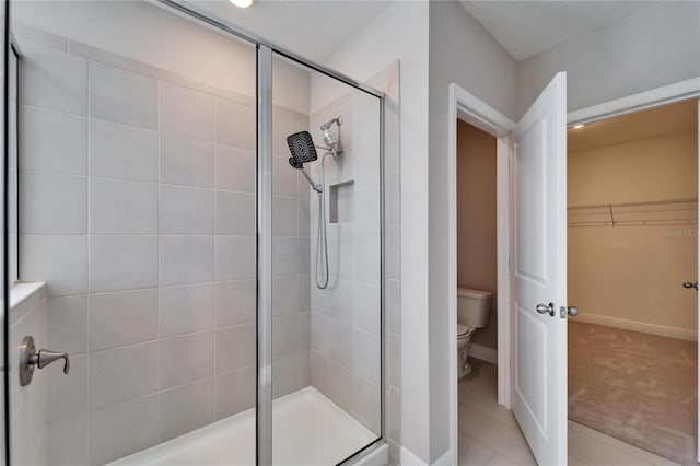 bathroom with walk in shower, toilet, tile patterned flooring, and a textured ceiling