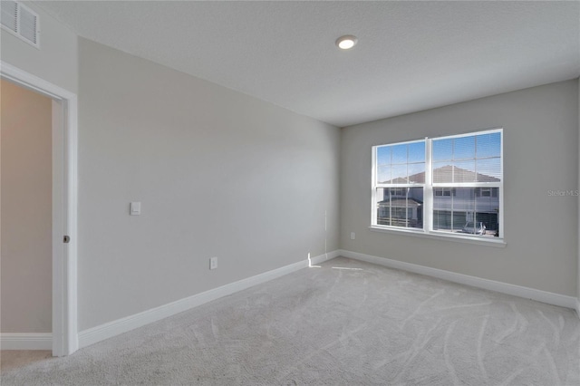 unfurnished room featuring light carpet