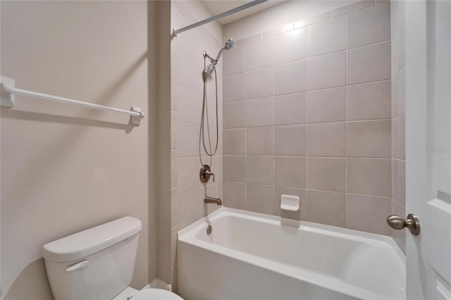 bathroom with toilet and tiled shower / bath combo