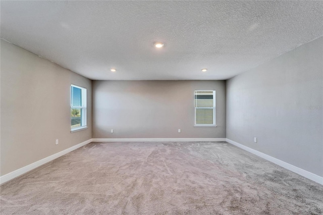 carpeted spare room featuring a textured ceiling