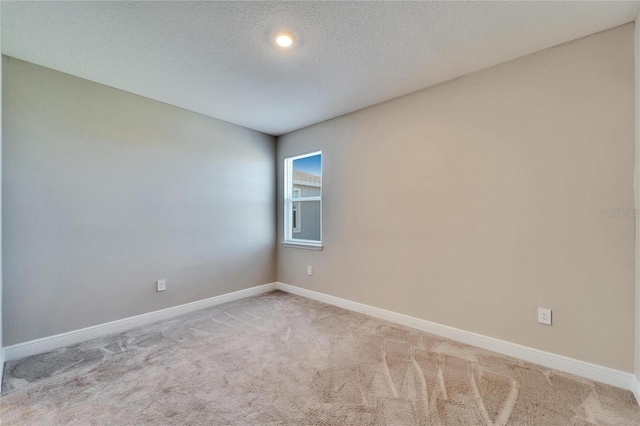 carpeted empty room with a textured ceiling