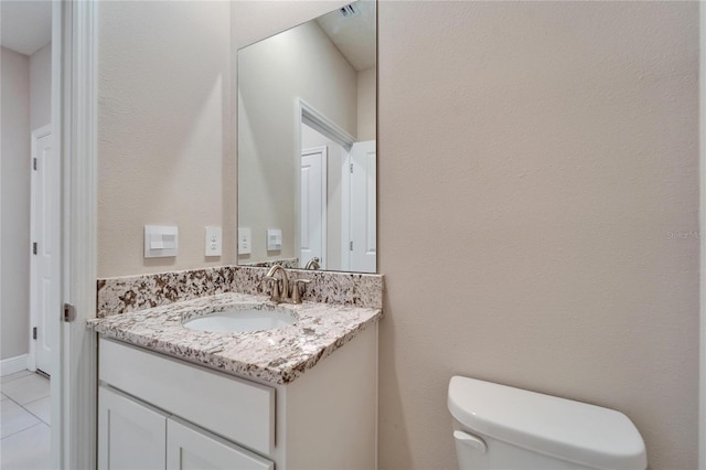 bathroom featuring tile patterned floors, vanity, and toilet