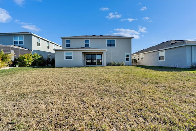 rear view of house featuring a lawn