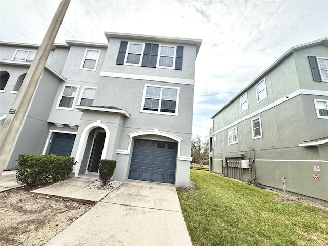 townhome / multi-family property featuring a garage and a front yard