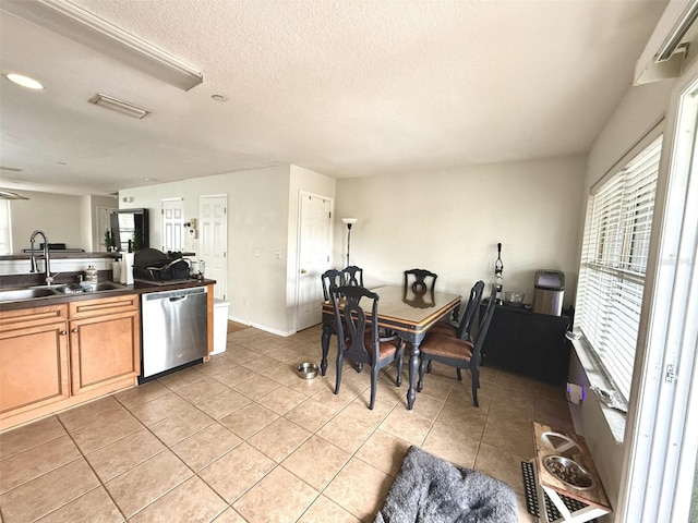 kitchen with dishwasher, sink, a textured ceiling, and light tile patterned floors