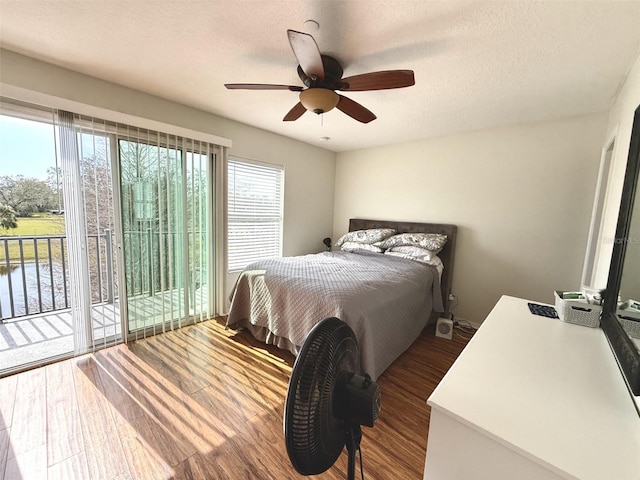 bedroom featuring access to exterior, hardwood / wood-style flooring, a textured ceiling, and ceiling fan