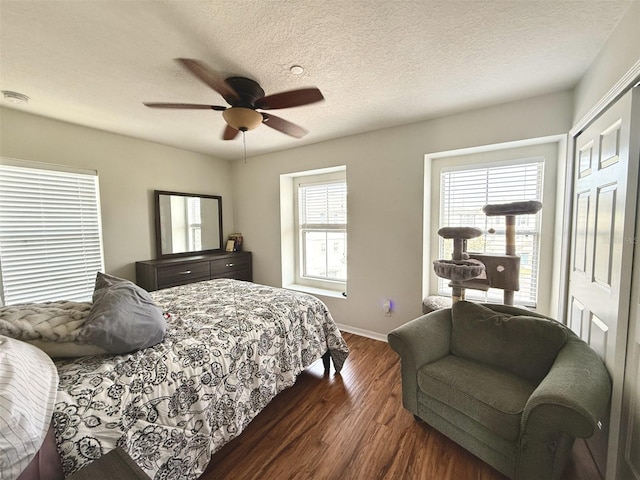 bedroom with ceiling fan, dark wood-type flooring, and a textured ceiling