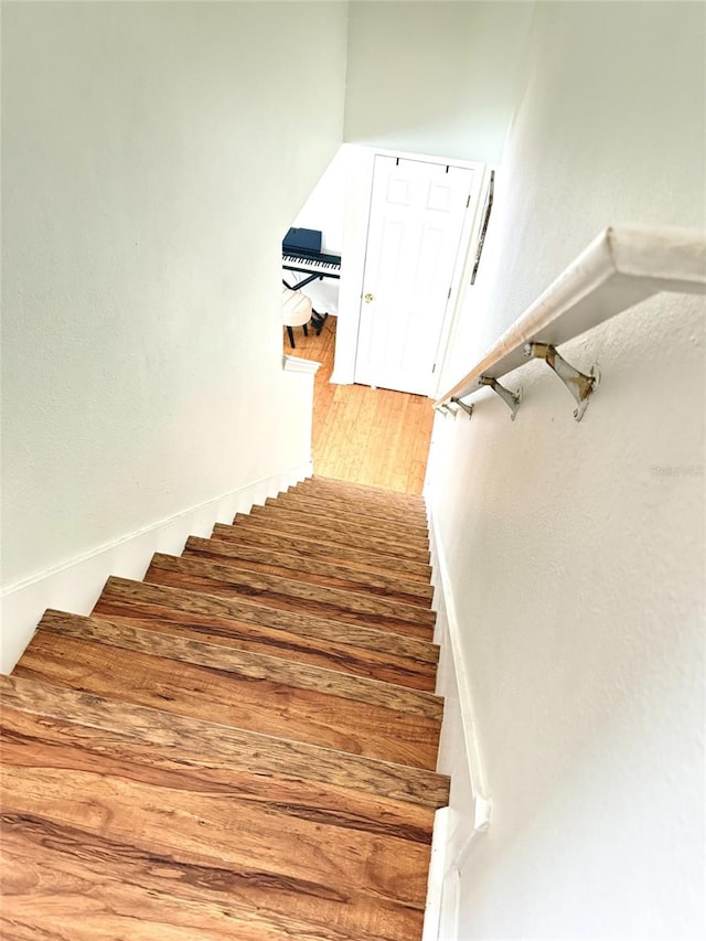 staircase with hardwood / wood-style floors