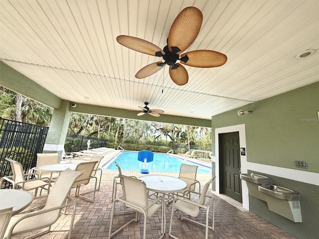 view of patio with ceiling fan and a fenced in pool