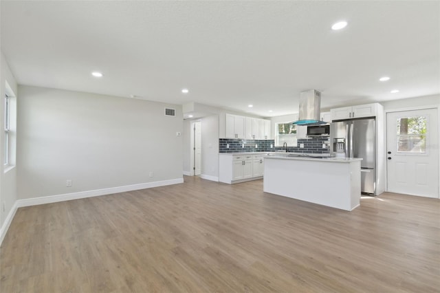 kitchen featuring stainless steel refrigerator with ice dispenser, island range hood, a center island, decorative backsplash, and white cabinets