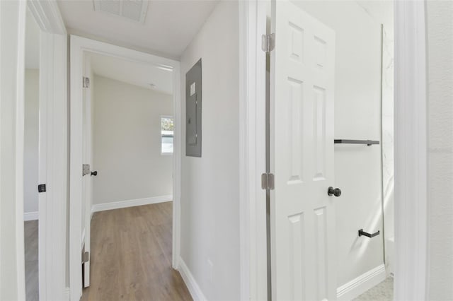 hallway featuring electric panel and light hardwood / wood-style floors