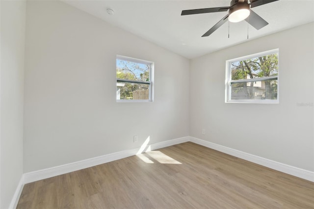 spare room featuring plenty of natural light, ceiling fan, and light hardwood / wood-style flooring