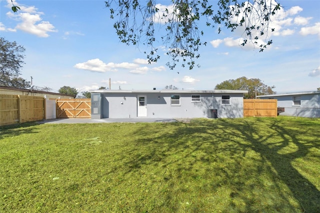 rear view of property featuring a lawn and central air condition unit