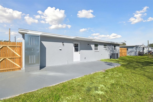 back of house featuring central AC unit, a yard, and a patio