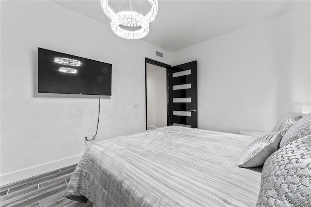 5120 Marina Way Unit 14002, Tampa, FL 33611 - bedroom with a notable chandelier, baseboards, visible vents, and wood finished floors