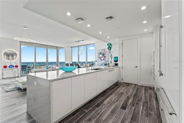 5120 Marina Way Unit 14002, Tampa, FL 33611 - kitchen featuring wood finish floors, white cabinets, visible vents, and a sink