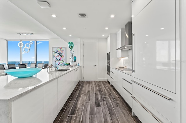 5120 Marina Way Unit 14002, Tampa, FL 33611 - kitchen with wall chimney range hood, modern cabinets, visible vents, and a sink