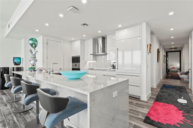 5120 Marina Way Unit 14002, Tampa, FL 33611 - kitchen featuring modern cabinets, visible vents, white cabinetry, built in appliances, and wall chimney exhaust hood