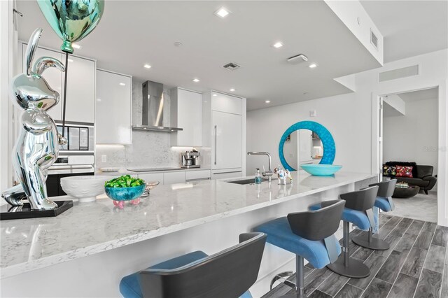 5120 Marina Way Unit 14002, Tampa, FL 33611 - kitchen featuring wall chimney range hood, modern cabinets, a sink, and visible vents