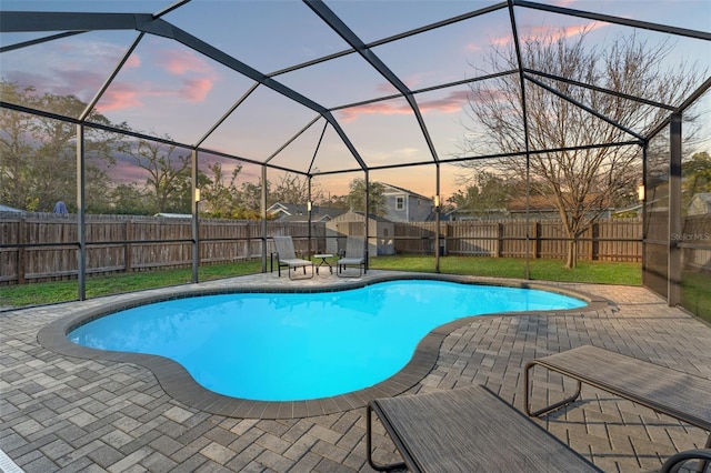 pool at dusk featuring a patio area and glass enclosure