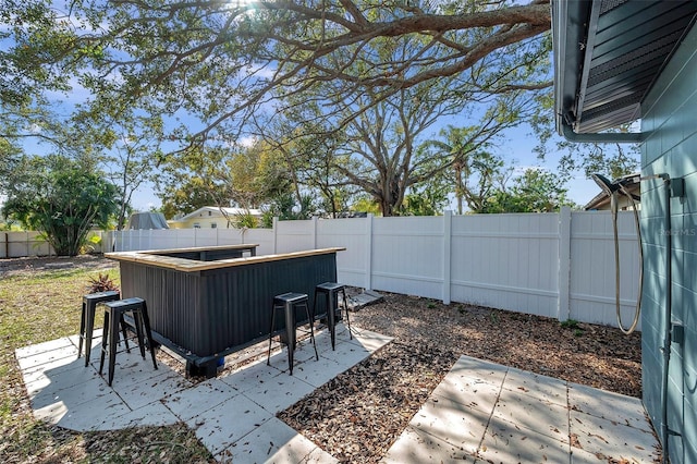 view of yard featuring a patio area, a fenced backyard, and outdoor dry bar