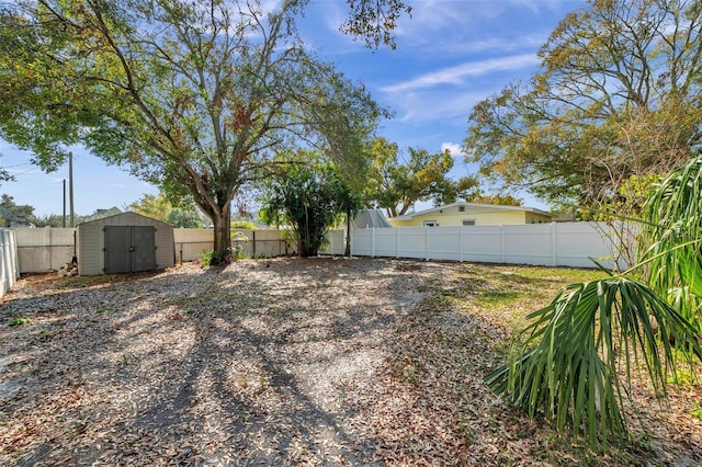 view of yard featuring a storage shed, an outbuilding, and a fenced backyard