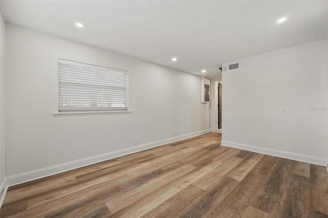 unfurnished room with recessed lighting, wood finished floors, and baseboards