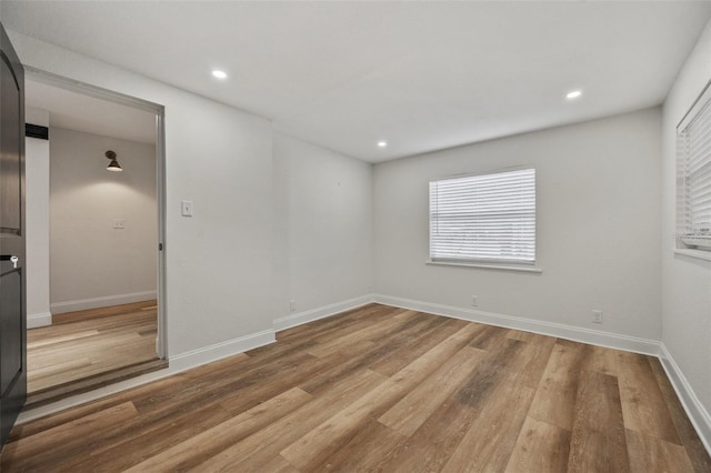 empty room with recessed lighting, baseboards, and wood finished floors