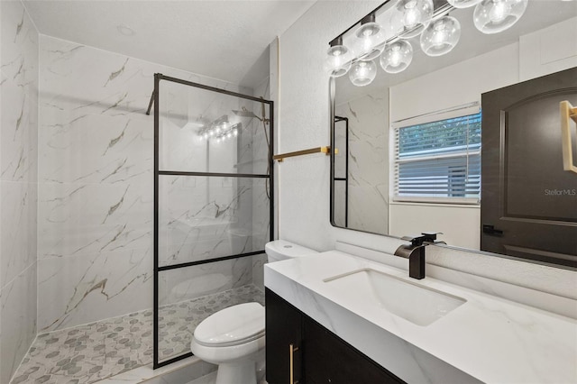 bathroom featuring a marble finish shower, toilet, and vanity