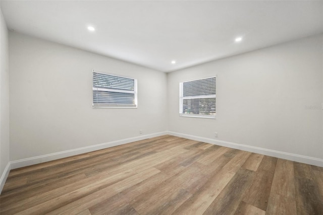 unfurnished room with recessed lighting, baseboards, and light wood finished floors