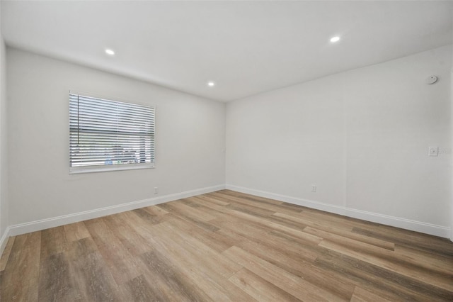 spare room with recessed lighting, baseboards, and light wood-style flooring