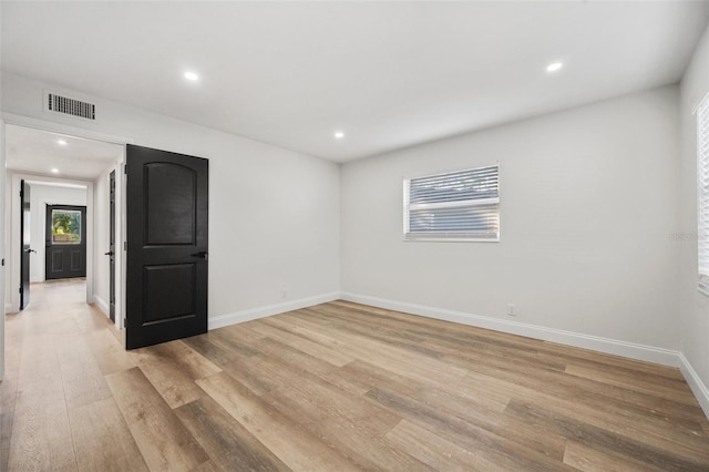 empty room featuring recessed lighting, baseboards, visible vents, and light wood finished floors