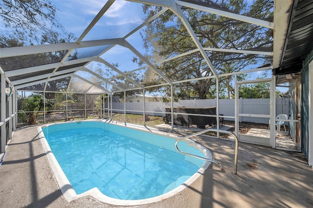 view of pool with a fenced in pool, a patio, a fenced backyard, and glass enclosure