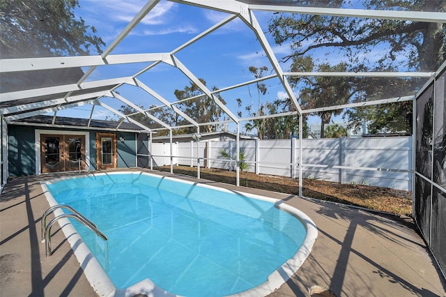 view of swimming pool featuring a fenced in pool, glass enclosure, french doors, a fenced backyard, and a patio area