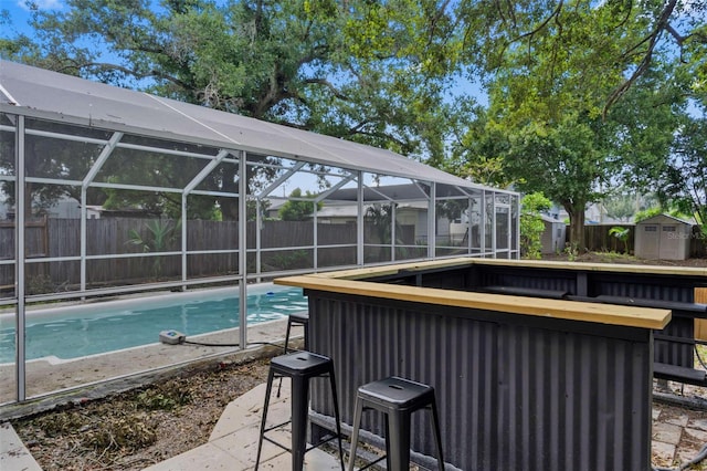 view of swimming pool featuring outdoor dry bar, a storage unit, an outdoor structure, and a fenced backyard