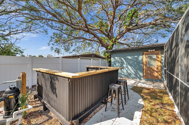 exterior space with a fenced backyard and outdoor dry bar