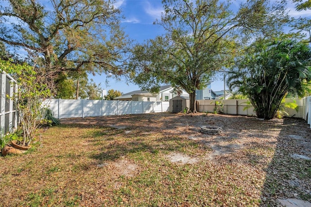 view of yard with a storage shed, a fenced backyard, and an outdoor structure