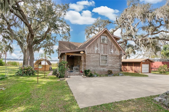 cabin with a garage and a front lawn