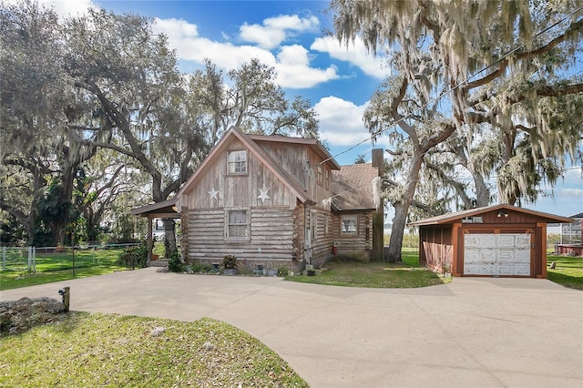 log-style house with a garage, an outdoor structure, and a front yard