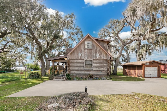 log home with a garage, an outdoor structure, and a front yard