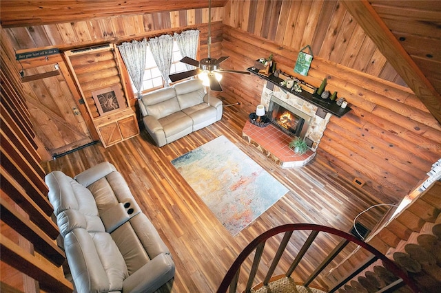 living room with a brick fireplace, hardwood / wood-style floors, and rustic walls