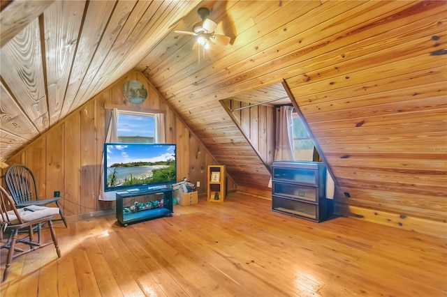 additional living space with lofted ceiling, light hardwood / wood-style flooring, wooden ceiling, and wood walls