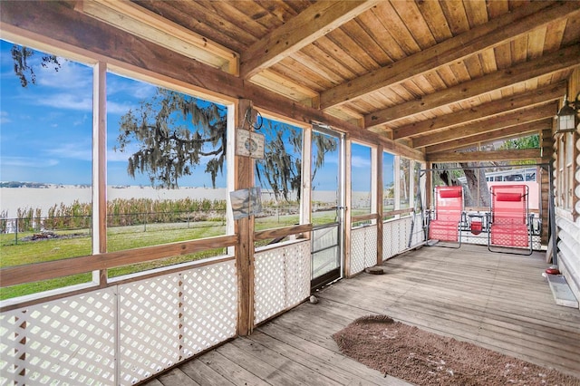 unfurnished sunroom featuring a water view, wood ceiling, and vaulted ceiling with beams