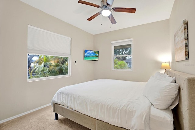 bedroom with multiple windows, light colored carpet, and ceiling fan