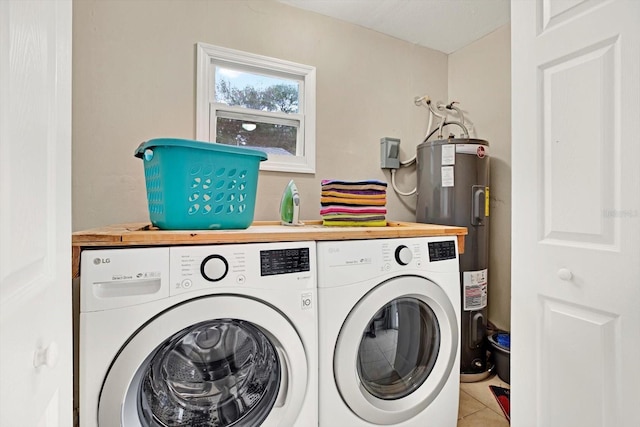 laundry room with water heater, tile patterned flooring, and washer and dryer