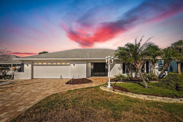 view of front of property with a garage and a lawn