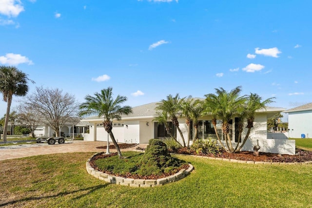 ranch-style house featuring a garage and a front lawn